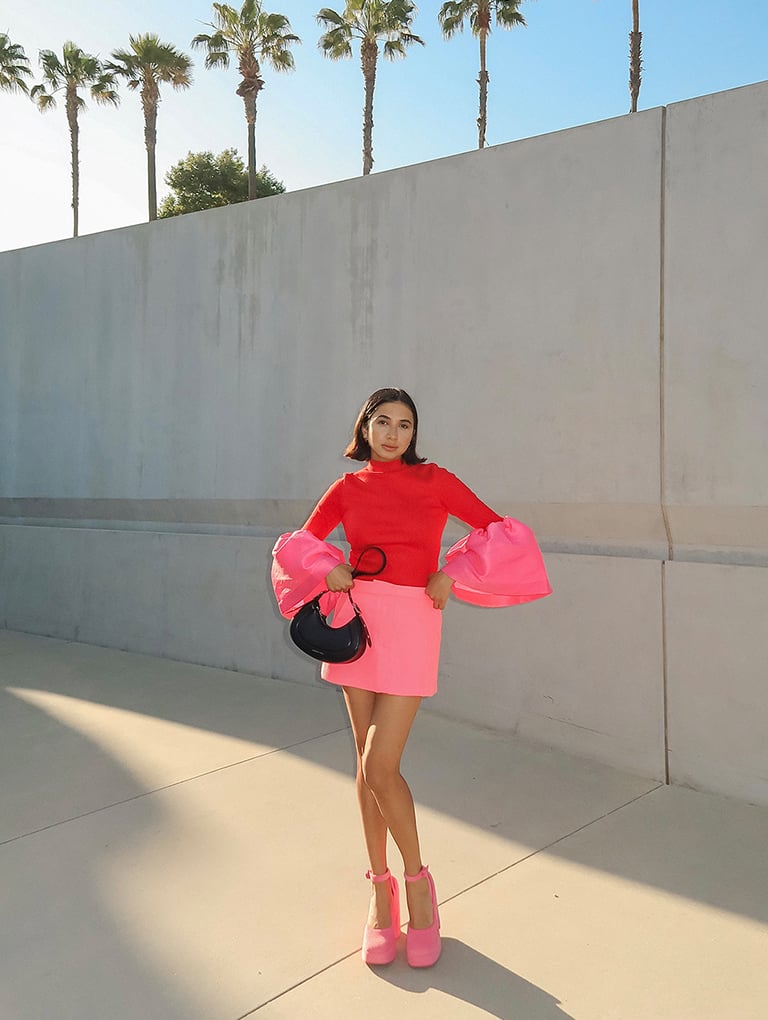 Women’s Petra curved shoulder bag in black and Loey ankle-strap platform pumps in pink, as seen on Navdeep Kaur – CHARLES & KEITH