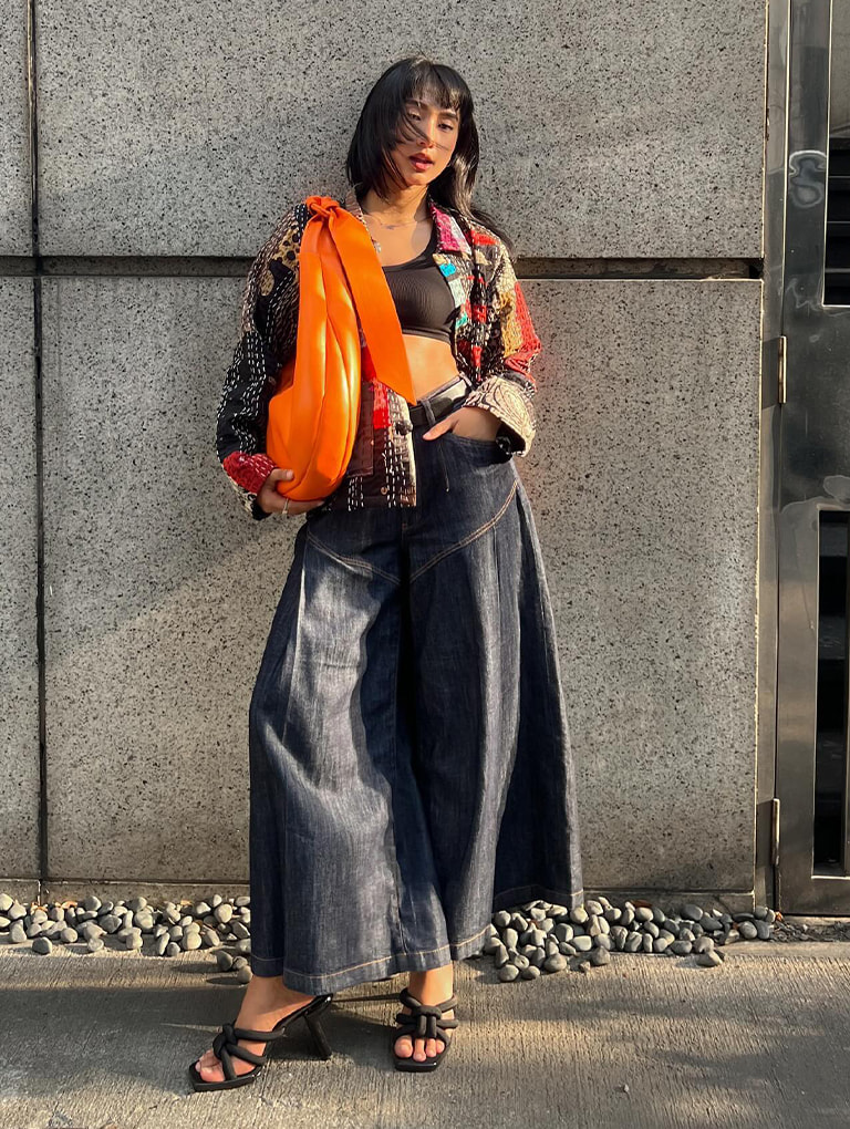 Women’s Toni knotted curved hobo bag in orange and Toni knotted puffy-strap mules in black textured, as seen on Trish Filart – CHARLES & KEITH