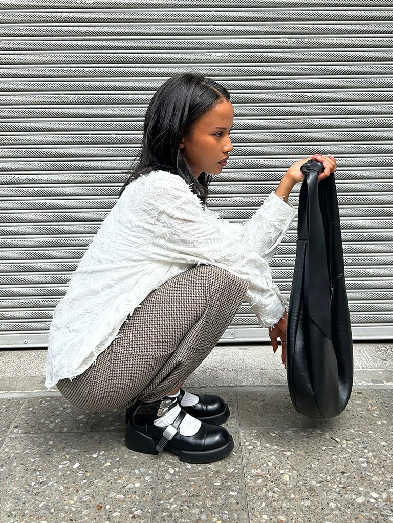 Women’s Toni knotted curved hobo bag in noir & Robbie ankle-strap Mary Jane boots in black, as seen on Vi - CHARLES & KEITH