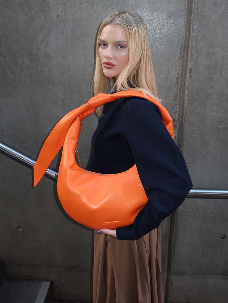 Women’s Toni Knotted Curved Hobo Bag in orange, as seen on Elodie Russell – CHARLES & KEITH