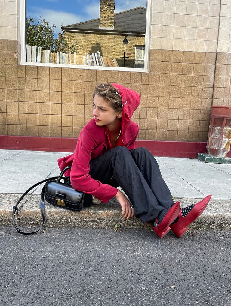 Women’s Robbie pointed-toe Mary Jane flats in red & Charlot elongated top handle bag in black, as seen on Ava Kalitowski - CHARLES & KEITH