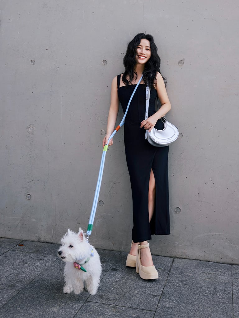 Women’s Petra curved shoulder bag in silver and Loey ankle-strap platform pumps in beige, as seen on Nikki Min – CHARLES & KEITH