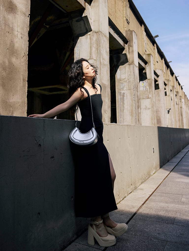 Women’s Petra curved shoulder bag in silver and Loey ankle-strap platform pumps in beige, as seen on Nikki Min – CHARLES & KEITH